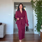 DRAPED CROSSOVER NECKLINE MIDI DRESS WITH GOLD-TONE BUCKLE DETAIL AND PEPLUM WAIST - BURGUNDY